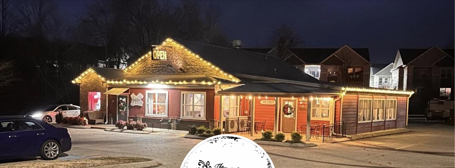 The BBQ Place Porch and Grill's real building in White House, TN, lit up at night with string lights along the roofline